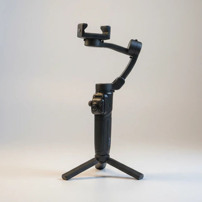 Estabilizador de cardán negro Raftec para smartphone con trípode integrado, ideal para vídeos fluidos y fotos estables.